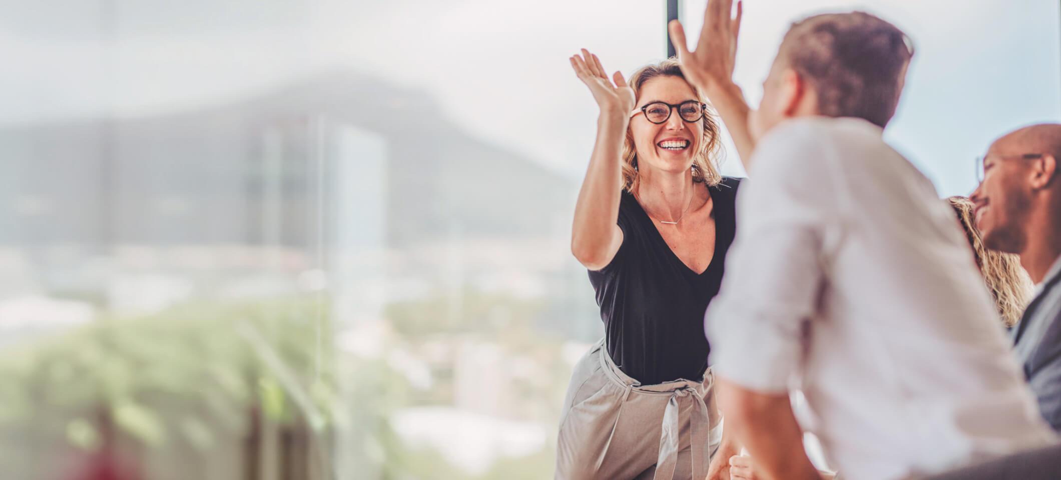 Medical billers exchange a high-five while engaging in networking for medical billing companies