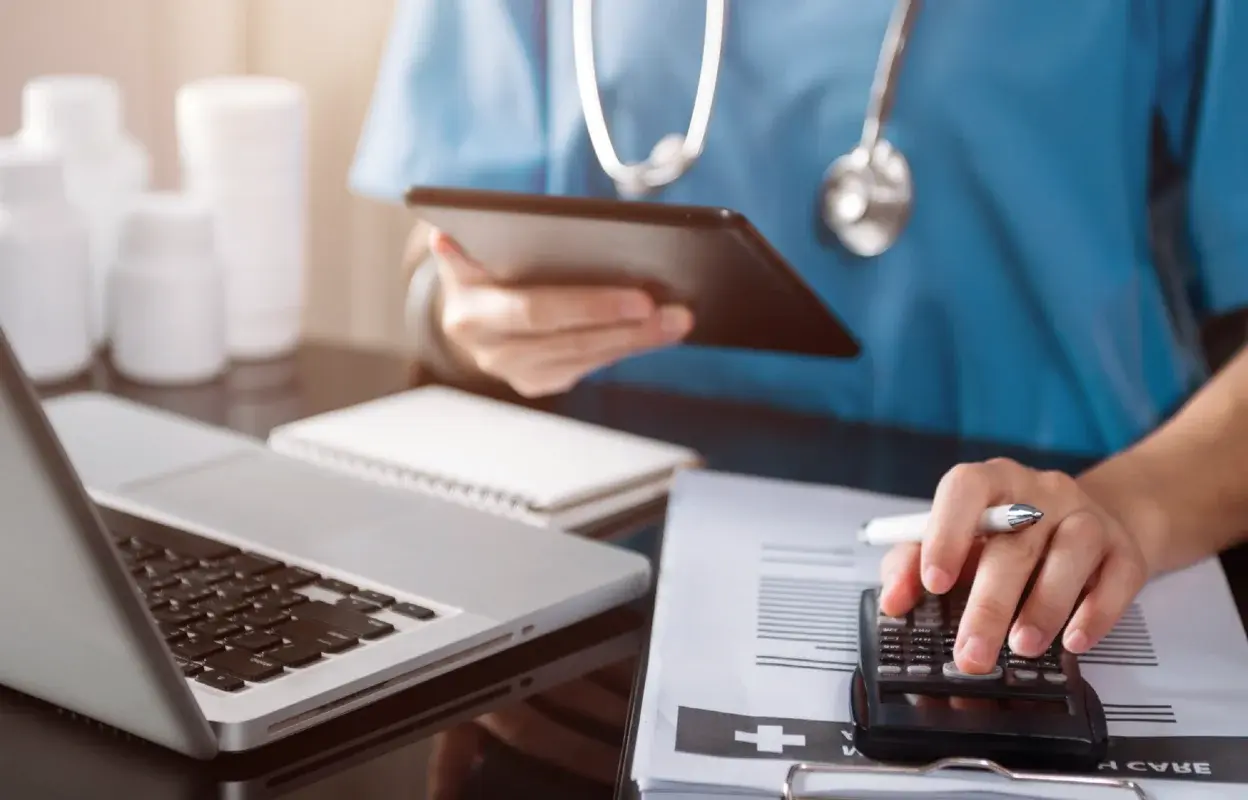 hand of medical professional using calculator