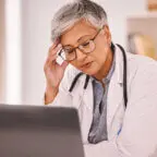 Doctor sits at computer displaying primary care physician burnout