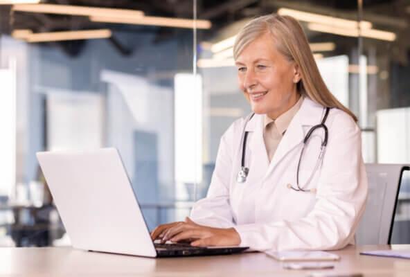 Physician reads February 2026 healthcare RCM news on computer
