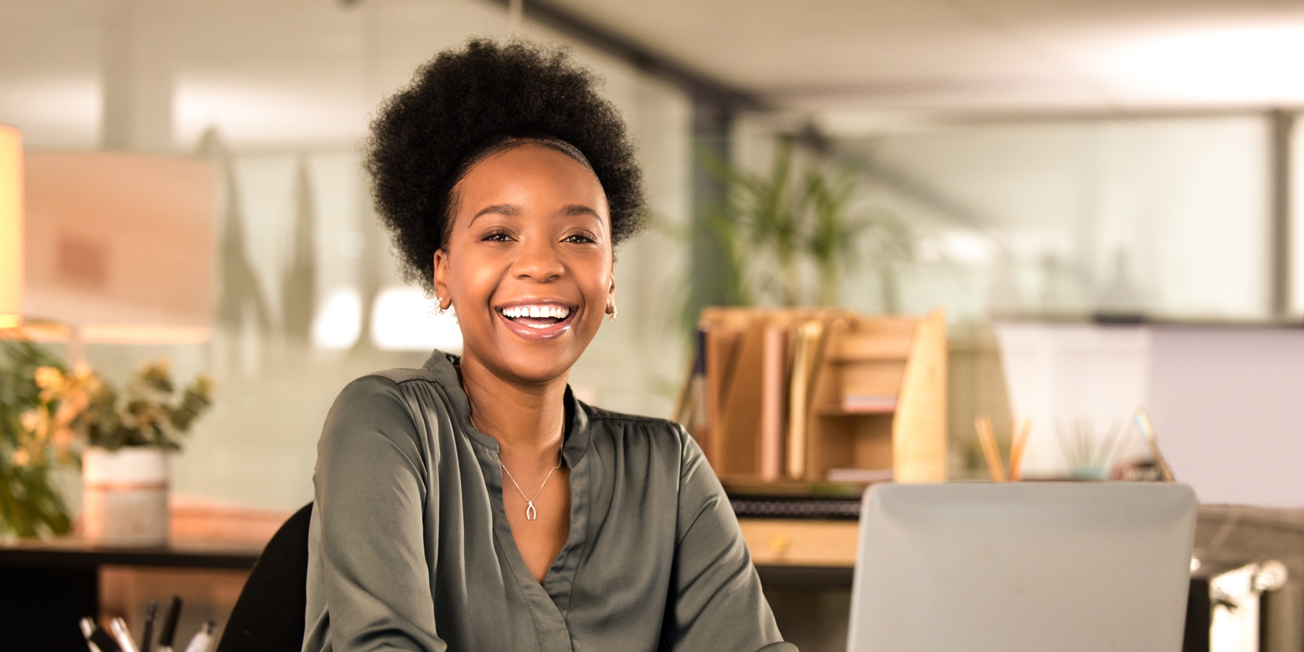 person in office smiling and using computer